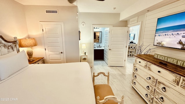 bedroom with visible vents, connected bathroom, and light wood-style floors