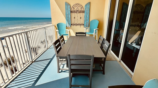 balcony featuring a view of the beach and a water view