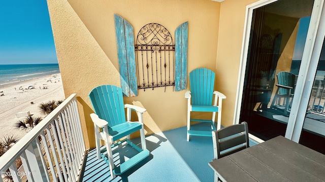 balcony featuring a beach view and a water view