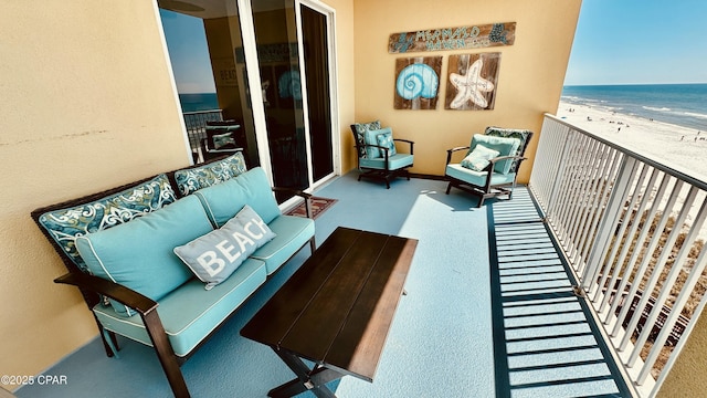 balcony with an outdoor living space, a water view, and a view of the beach