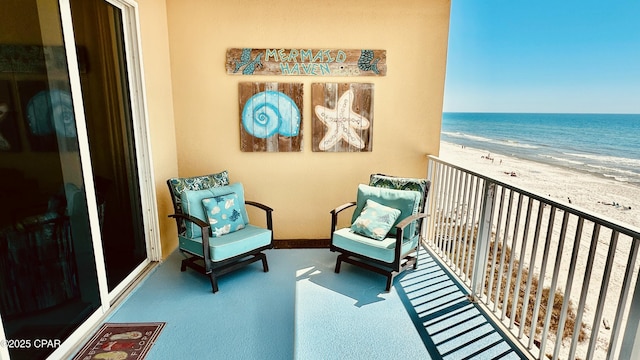 balcony with a water view and a view of the beach