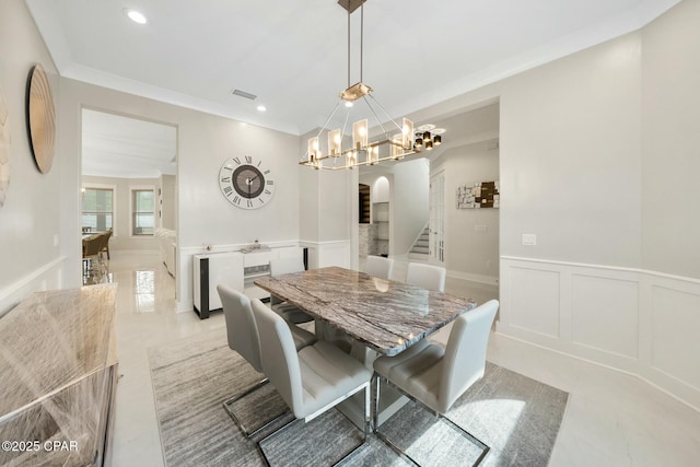 dining space featuring visible vents, a chandelier, stairway, arched walkways, and a decorative wall