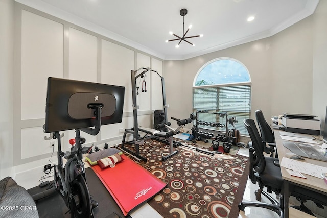 exercise area with an inviting chandelier and ornamental molding