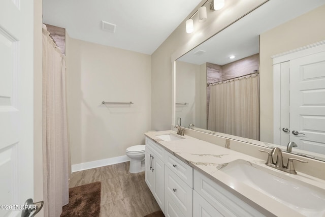 full bath with toilet, baseboards, visible vents, and a sink