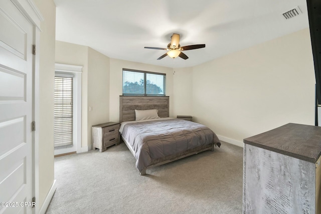 bedroom with visible vents, multiple windows, light colored carpet, and baseboards