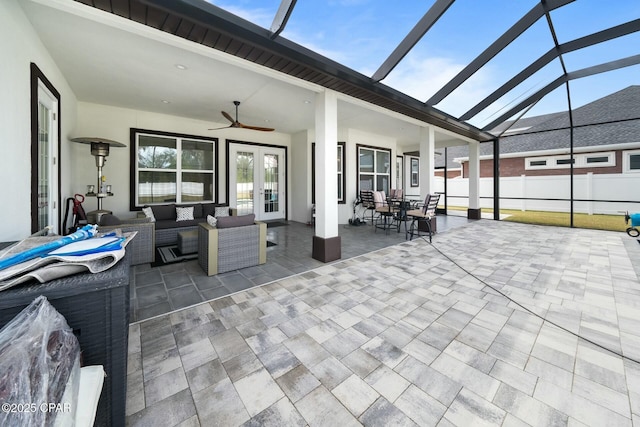 view of patio / terrace with glass enclosure, fence, ceiling fan, french doors, and outdoor lounge area