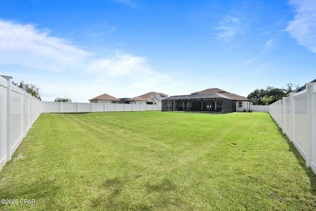 view of yard featuring a lanai and a fenced backyard