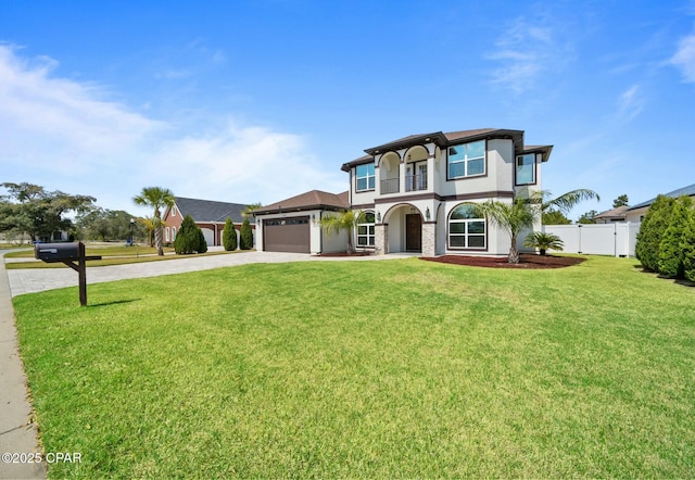 view of front facade with stucco siding, a front lawn, driveway, fence, and a garage