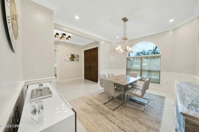 dining space featuring a wainscoted wall, recessed lighting, ornamental molding, a decorative wall, and a chandelier