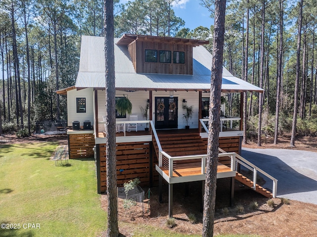 view of front of home featuring stairs, a front yard, french doors, and covered porch