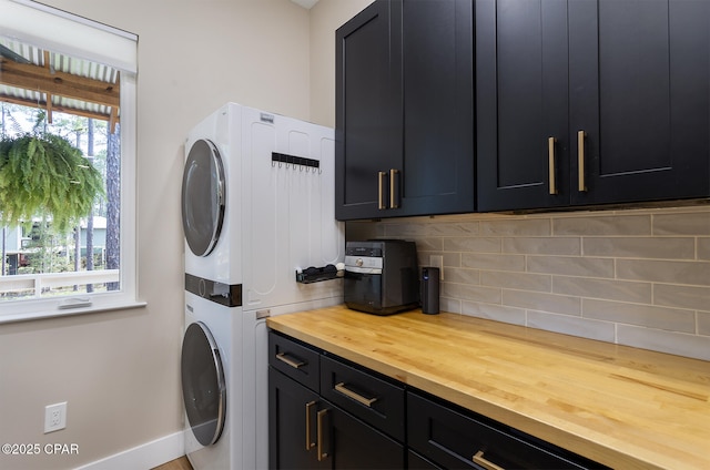 clothes washing area featuring stacked washer / dryer