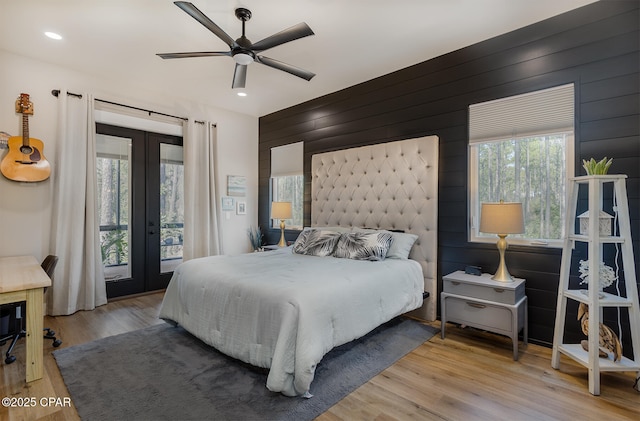 bedroom with wood finished floors, access to outside, recessed lighting, and french doors