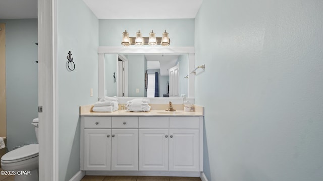 bathroom featuring toilet, vanity, and baseboards