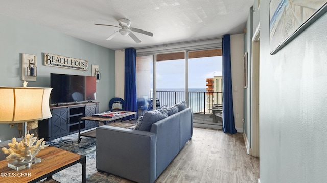 living area featuring ceiling fan and light wood finished floors