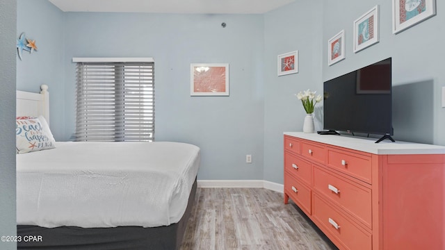 bedroom featuring baseboards and light wood finished floors