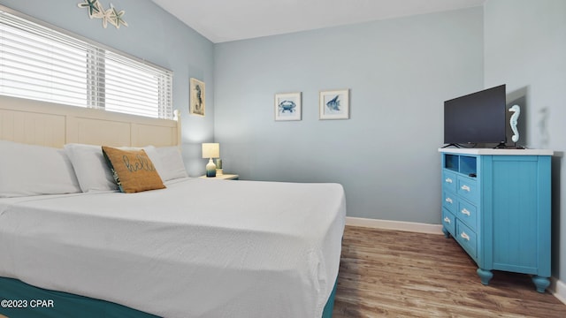 bedroom featuring wood finished floors and baseboards