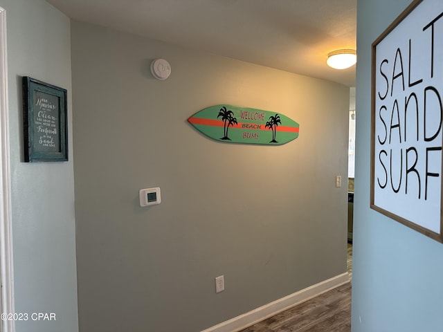 corridor with baseboards and dark wood-style floors