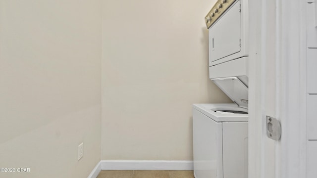 laundry room featuring laundry area, baseboards, and stacked washer and clothes dryer