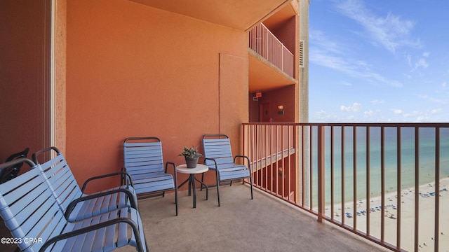 balcony featuring a beach view and a water view