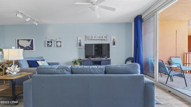 living room with track lighting, a ceiling fan, and light wood finished floors