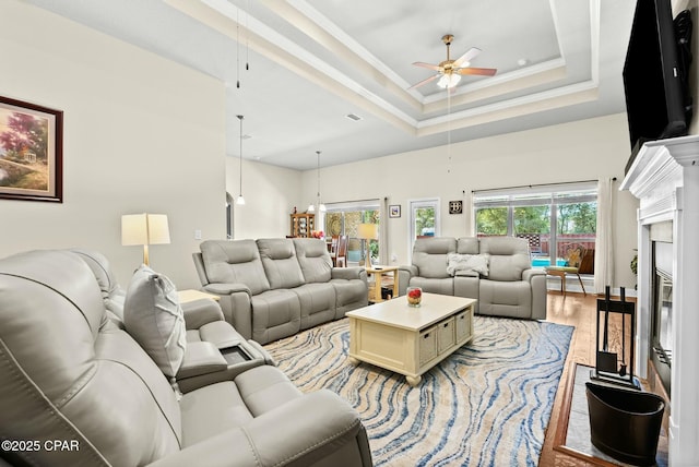 116 Lake Merial Blvd, Panama City, FL 32409 - living room with ceiling fan, a fireplace, light wood finished floors, a towering ceiling, and a raised ceiling