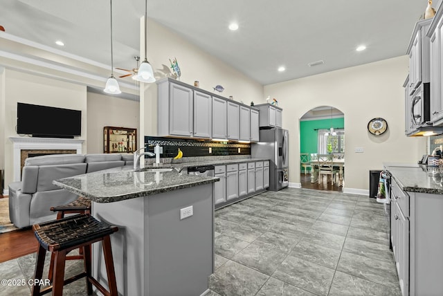 116 Lake Merial Blvd, Panama City, FL 32409 - kitchen featuring a sink, stainless steel appliances, arched walkways, a peninsula, and tasteful backsplash