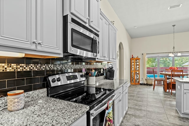 116 Lake Merial Blvd, Panama City, FL 32409 - kitchen featuring stainless steel appliances, arched walkways, decorative backsplash, and hanging light fixtures