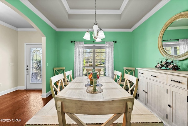 116 Lake Merial Blvd, Panama City, FL 32409 - dining space featuring a chandelier, light wood-style flooring, arched walkways, a tray ceiling, and baseboards