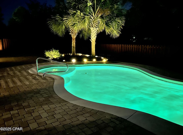 116 Lake Merial Blvd, Panama City, FL 32409 - pool at night featuring a fenced backyard and a patio