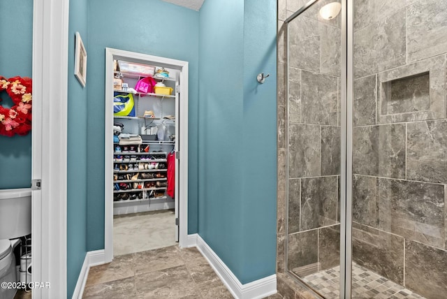 116 Lake Merial Blvd, Panama City, FL 32409 - bathroom featuring a shower stall, toilet, a spacious closet, and baseboards