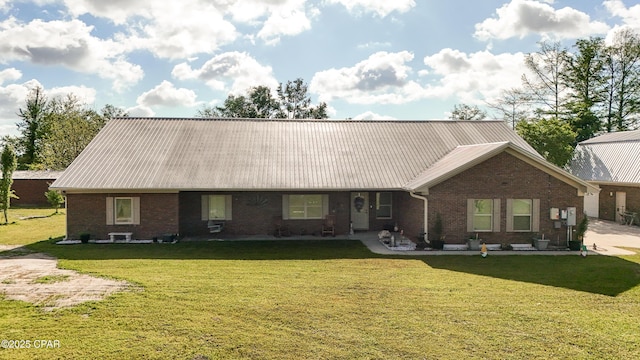 7224 Resota Ln, Panama City, FL 32409 - rear view of property featuring metal roof, brick siding, and a lawn