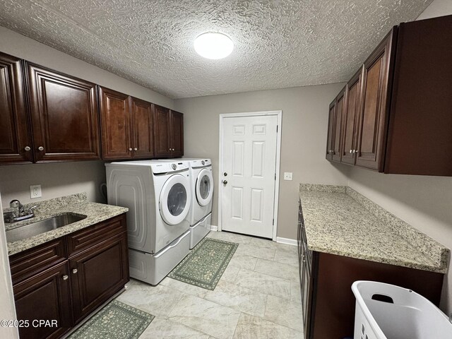 7224 Resota Ln, Panama City, FL 32409 - washroom featuring a sink, a textured ceiling, cabinet space, and washer and dryer