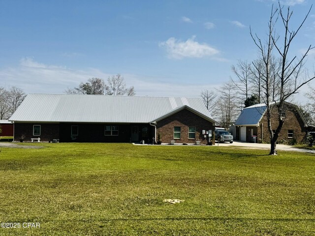 7224 Resota Ln, Panama City, FL 32409 - view of front of house featuring metal roof, brick siding, and a front lawn