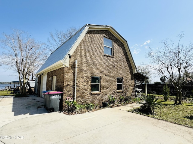 7224 Resota Ln, Panama City, FL 32409 - view of side of property featuring a gambrel roof, brick siding, and metal roof