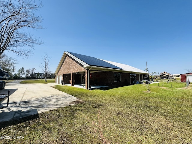 7224 Resota Ln, Panama City, FL 32409 - view of home's exterior featuring brick siding, driveway, a garage, solar panels, and a lawn
