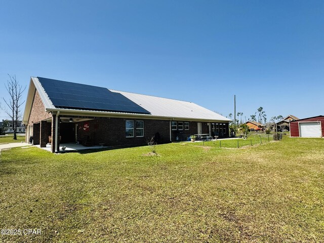 7224 Resota Ln, Panama City, FL 32409 - rear view of house with a lawn, brick siding, solar panels, and fence