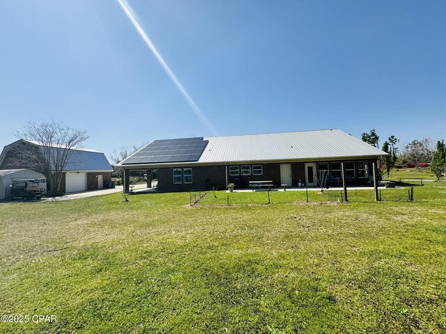7224 Resota Ln, Panama City, FL 32409 - back of house featuring a yard, roof mounted solar panels, and a detached garage