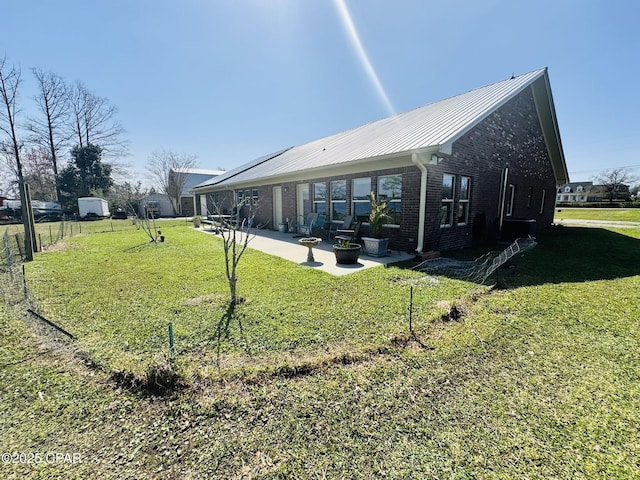 7224 Resota Ln, Panama City, FL 32409 - rear view of property with a lawn, a patio area, brick siding, and metal roof