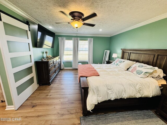 7224 Resota Ln, Panama City, FL 32409 - bedroom with a textured ceiling, light wood-style flooring, a ceiling fan, and ornamental molding