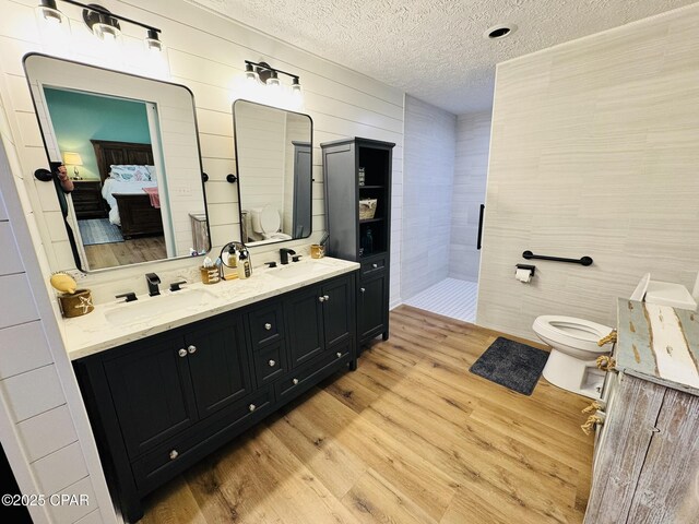 7224 Resota Ln, Panama City, FL 32409 - ensuite bathroom with toilet, a textured ceiling, a sink, and wood finished floors
