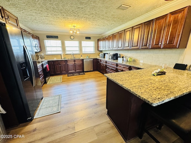 7224 Resota Ln, Panama City, FL 32409 - kitchen with a peninsula, light wood-style flooring, a sink, crown molding, and appliances with stainless steel finishes