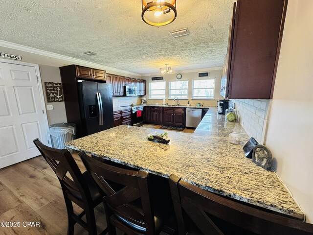 7224 Resota Ln, Panama City, FL 32409 - kitchen featuring a peninsula, stainless steel appliances, crown molding, and visible vents