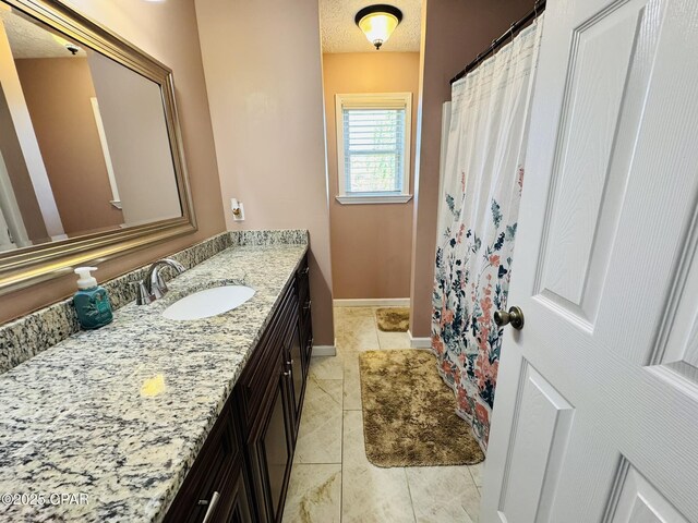 7224 Resota Ln, Panama City, FL 32409 - full bath with a shower with curtain, a textured ceiling, baseboards, tile patterned flooring, and vanity