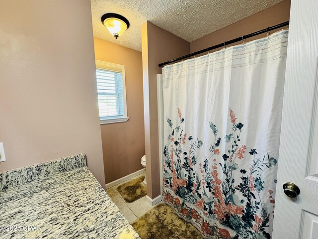 7224 Resota Ln, Panama City, FL 32409 - full bath with a shower with shower curtain, toilet, a textured ceiling, and tile patterned floors