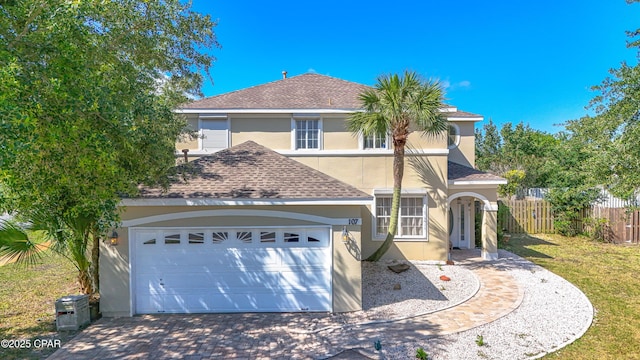 107 Summerwood Dr, Panama City Beach, FL 32413 - view of front facade with stucco siding, a shingled roof, an attached garage, and driveway
