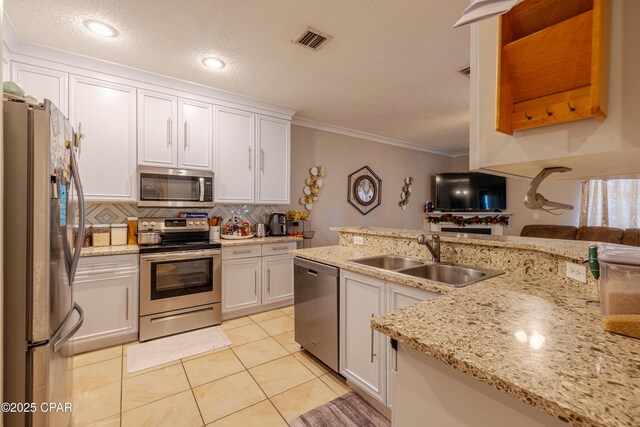 107 Summerwood Dr, Panama City Beach, FL 32413 - kitchen with appliances with stainless steel finishes, a sink, backsplash, crown molding, and white cabinetry