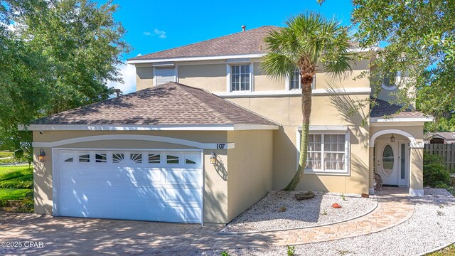 107 Summerwood Dr, Panama City Beach, FL 32413 - view of front facade with stucco siding, a shingled roof, a garage, and driveway