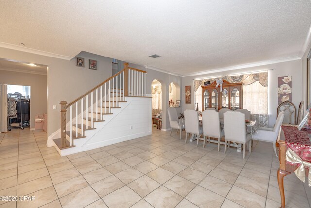 107 Summerwood Dr, Panama City Beach, FL 32413 - tiled living room with crown molding, arched walkways, stairs, and a textured ceiling