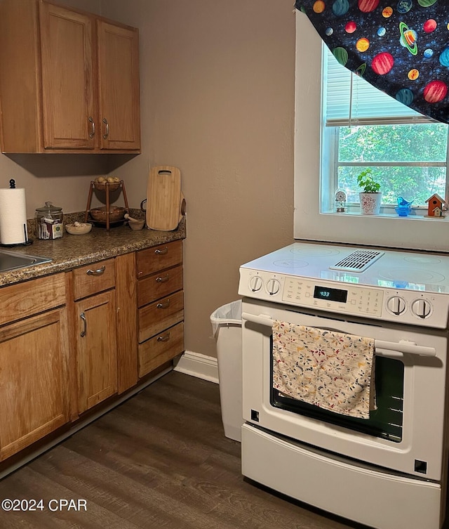 603 W Kansas Ave, Bonifay, FL 32425 - kitchen with brown cabinets, dark countertops, white electric stove, baseboards, and dark wood-style flooring