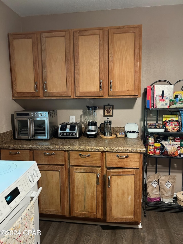 603 W Kansas Ave, Bonifay, FL 32425 - kitchen with brown cabinetry, a toaster, range with electric stovetop, and dark wood-type flooring